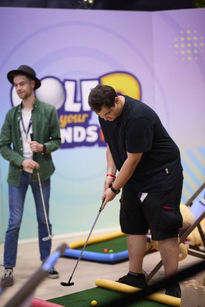 Zwei LGA-Mitglieder beim Minigolf am Stand von Golf With Your Friends 2, Gamescom 2025